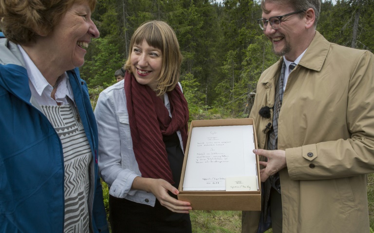 L'artiste écossaise Katie Paterson (c), la mair d'Oslo Marianne Borgen et l'auteur Sjon avec son manuscrit pour la bibliothèque du futur, dans une forêt près d'Oslo, le 2 juin 2017 Bjorvika Utvikling/AFP/Archives / Kristin von Hirsch
